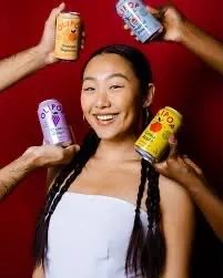 Personne heureuse tenant des canettes Olipop – soda sain prébiotique sans culpabilité