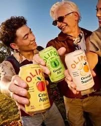Deux personnes partageant des canettes Olipop en plein air – boisson saine pour la santé digestive